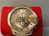 gold watch on a red box on a white surface