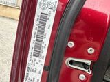 une portière de voiture rouge sur laquelle est collé un autocollant