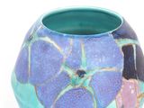 a blue vase with purple and green designs on it