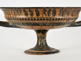 a black and brown vase with a handle on it