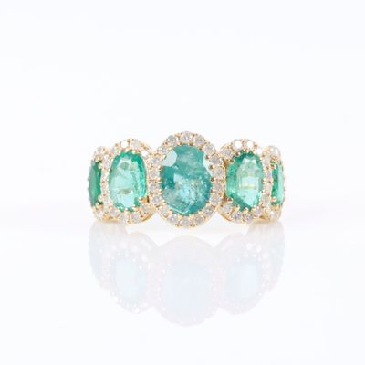 une bague sertie de trois pierres d’émeraude et de diamants