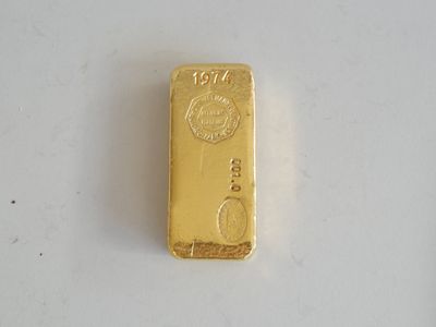 gros plan d'un lingot d'or sur une surface blanche