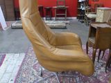 a brown leather chair and a small table in a room