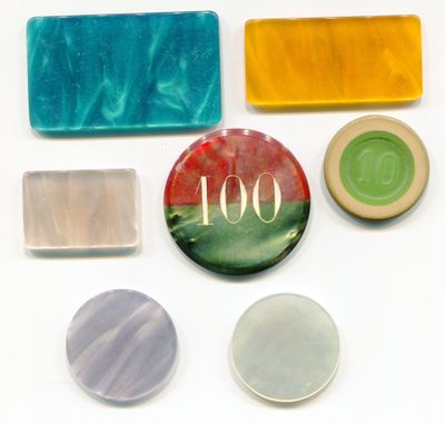plusieurs savons de différentes couleurs et des pains de savon posés sur une surface blanche