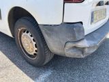 the rear end of a white truck with a flat tire