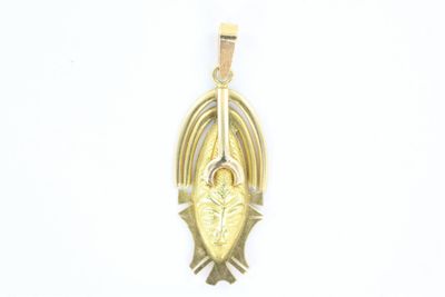 gros plan d'un pendentif en or sur fond blanc