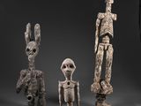 un ensemble de trois figurines en bois sculpté représentant un homme, une femme et un enfant