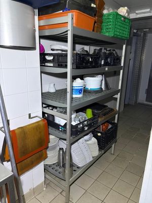 a metal rack with many items on it in a kitchen