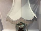 a lamp that is sitting on a table with a white shade