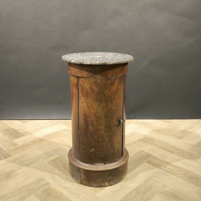 une petite table en bois avec un plateau en marbre, posée sur un parquet