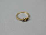a gold ring with two small beads on top of it