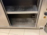 a stainless steel oven with a door open on a tiled floor