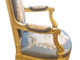 an image of a blue and gold chair with a floral upholstered back