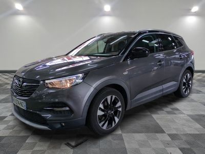 Le SUV gris est garé sur un sol en carrelage à damier.