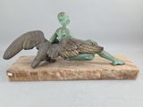 bronze statue of a boy sitting on a bird on a marble base