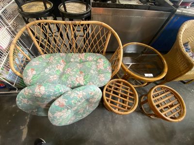 several wicker chairs and a chair in a room with a bird cage