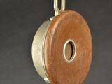 a small wooden object with a metal handle on a stand