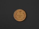 a close up of a gold coin on a black surface
