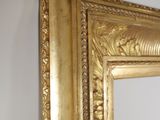 a picture of a gold framed mirror hanging on a wall