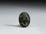 une ancienne pièce de monnaie en bronze sur laquelle figure la tête d'un homme