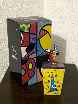 une figurine de Mickey Mouse dans une boîte, à côté d'une boîte contenant des figurines de Mickey Mouse