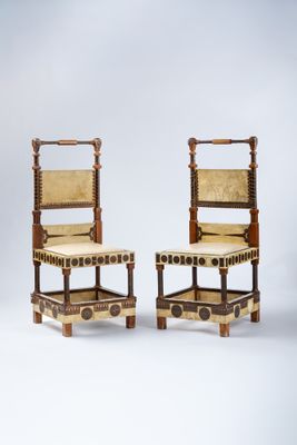 paire de chaises anciennes avec une structure en bois et des assises recouvertes de cuir