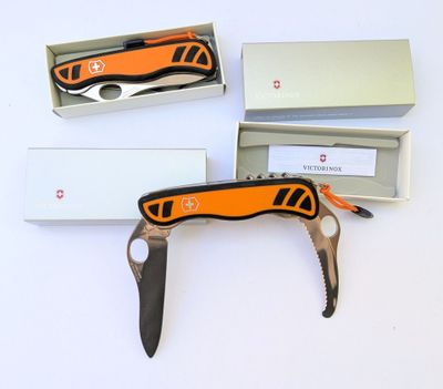 un couteau suisse orange et noir dans une boîte