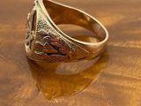 a gold signet ring on a wooden table