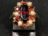 an image of a ring with a garnett and pearls on it