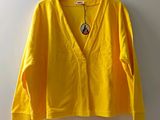 La chemise jaune est suspendue à un cintre accroché au mur.