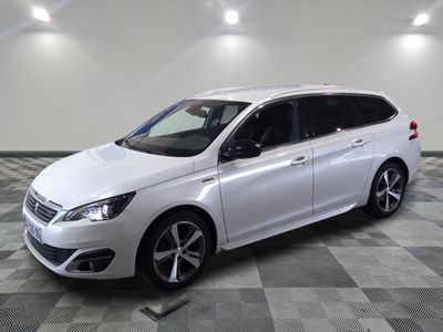 la voiture blanche est garée sur un sol en damier dans le garage