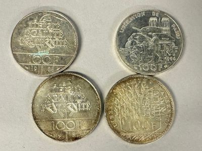 four different british coins sitting on top of a white surface