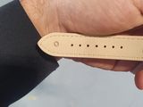 a person holding a leather watch strap in their hand