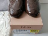 two pairs of brown shoes sitting on top of a box next to a handbag