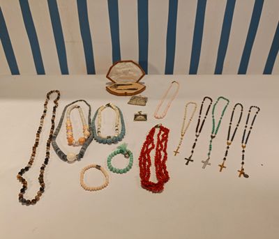 many necklaces and bracelets laid out on a table