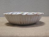a white bowl sitting on a table with a brown table cloth