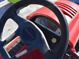 a steering wheel on a red toy car with a clock on it