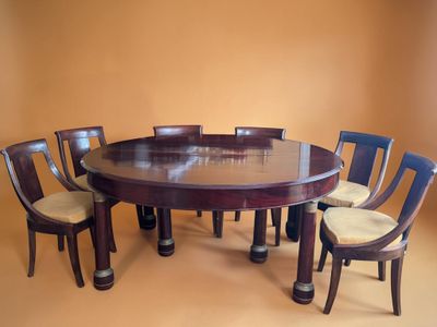 a round table with six chairs around it in a room