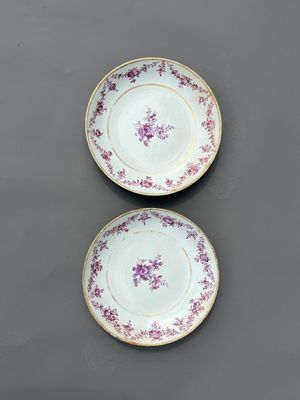 Deux assiettes ornées de fleurs violettes sont posées sur une table.