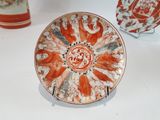 a plate with a design on it sitting on a table next to other plates
