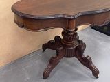 a small table with a wooden top on a cement floor