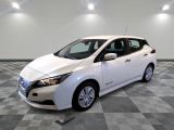 the white nissan leaf is parked on a checkered tile floor