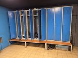 une rangée de casiers bleus dans une pièce au sol carrelé