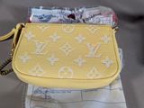 a yellow purse that is sitting on top of a piece of paper