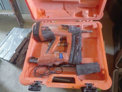 a tool box with a hammer and a nail gun in it