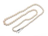 un collier de perles blanches avec un fermoir en argent sur fond blanc
