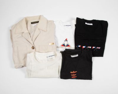 three shirts and a jacket sitting on top of a white table