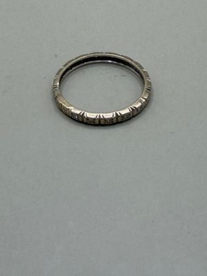 une bague en argent posée sur une table, sur fond blanc