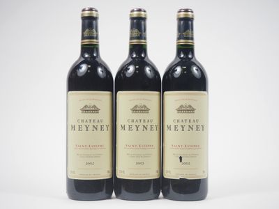 trois bouteilles de vin rouge posées sur une table blanche