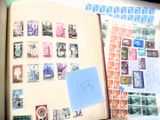 un livre ouvert avec des timbres, posé sur une table